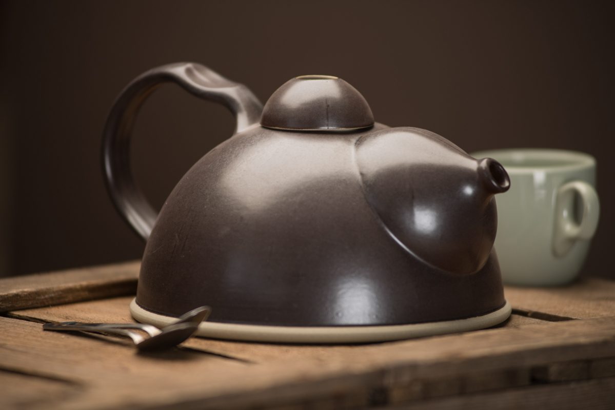 Black Teapot with Cup and Spoons On Wooden Crate