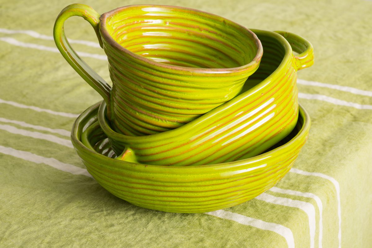 A Stack of Green Earthenware on Green Linen